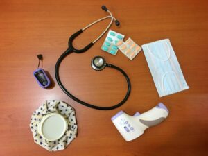 Caregiver checking a walker, blood pressure monitor, and organized medical supplies in a bright home.